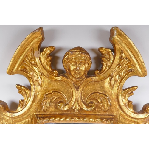 1046 - An Italian gilt wall mirror decorated with swags and masks, 28 x 65cm, losses