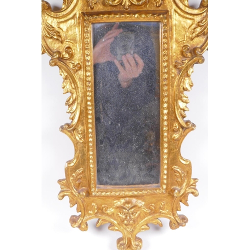 1046 - An Italian gilt wall mirror decorated with swags and masks, 28 x 65cm, losses