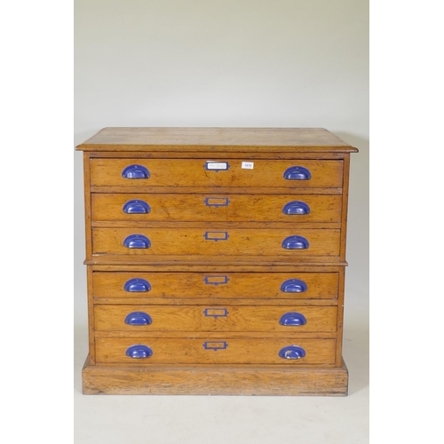 1070 - An early C20th golden oak plan chest in two sections of three drawers, 95 x 69cm, 89cm high