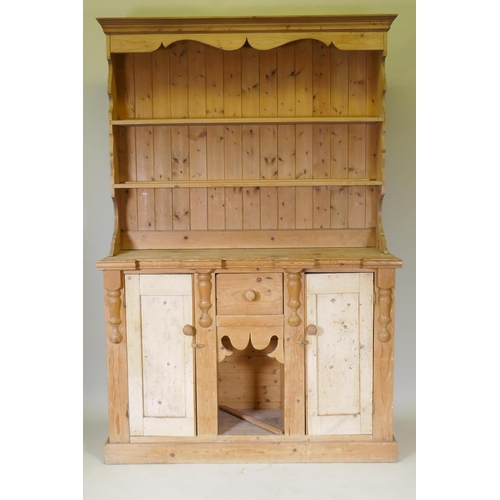 1071 - A pine dresser, the upper section with enclosed delft rack, the base with break-front top over two c... 