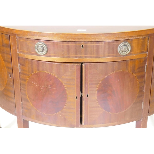 1072 - A C19th figured mahogany demi lune commode with two cupboards flanking a single drawer over two more... 