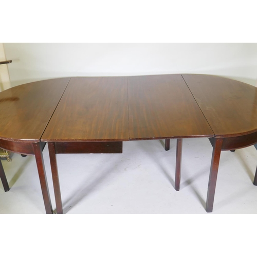 1079 - A Georgian mahogany dining table in three sections, two demi lune end sections and a centre section ... 