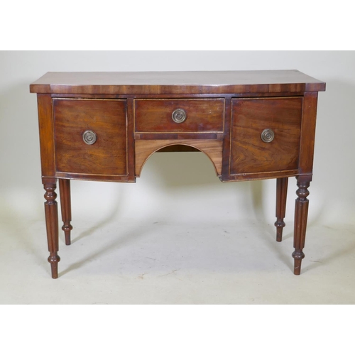 1104 - A Regency mahogany bow fronted kneehole sideboard with a cross banded top and three drawers, raised ... 