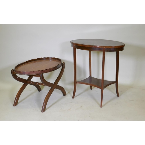 1109 - A Victorian mahogany two tier occasional table with oval top, raised on sabre supports, 70 x 43 x 70... 