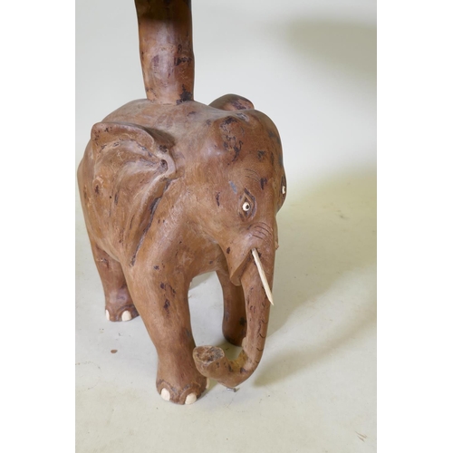 1111 - A carved wood elephant side table, 63cm diameter, 70cm high, top requires re-attaching