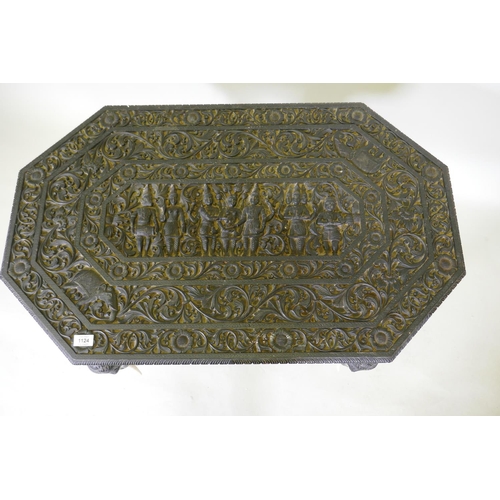 1124 - A C19th Ceylonese lacquered hardwood side table, the shaped top profusely carved with a procession a... 