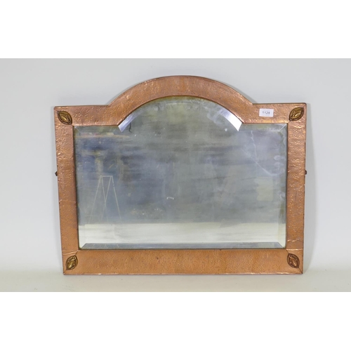 1128 - An Arts & Crafts hammered copper framed wall mirror with bevelled glass, in the manner of Libert... 