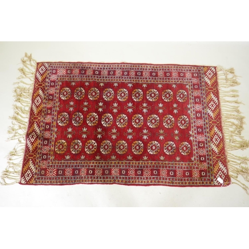 1136 - A vintage Persian rug with geometric designs on a red field, 94 x 150cm