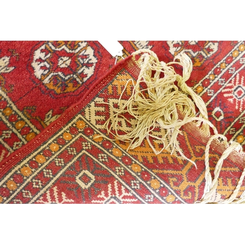 1136 - A vintage Persian rug with geometric designs on a red field, 94 x 150cm