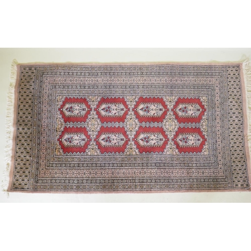 1137 - A hand woven wool Bokhara rug, medallion design on a pink ground, 94 x 150cm