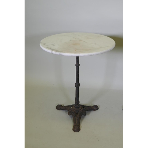 1140 - A pair of marble top bistro tables with cast iron bases, 73cm high x 61cm diameter