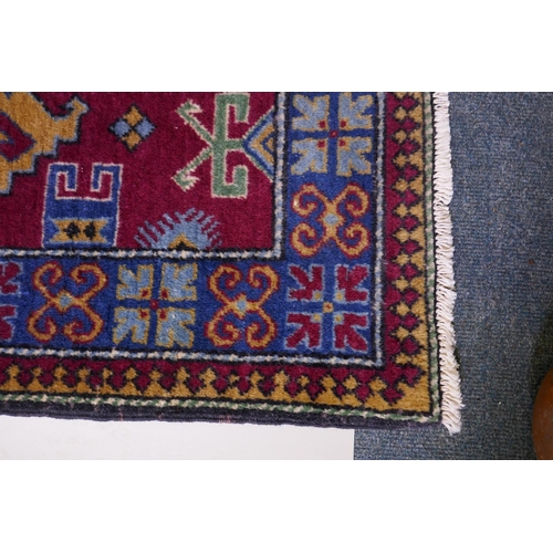 1147 - A claret wine ground wool caucasian runner with bespoke medallion design in unique colours, 322 x 73... 