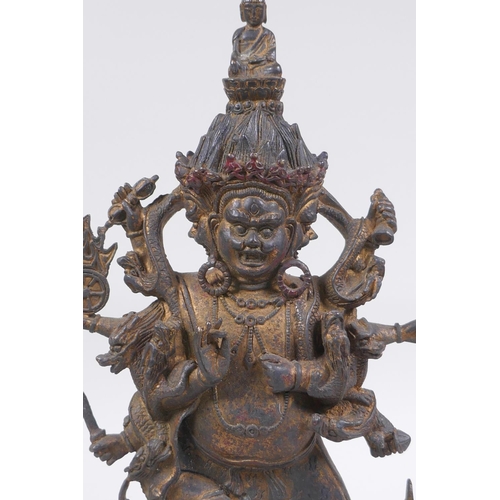 116 - A Tibetan bronze of a wrathful deity with the remnants of gilt patina, impressed double vajra mark t... 