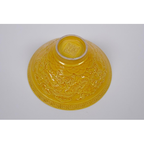 131 - A Chinese yellow ground porcelain bowl of conical form with raised twin dragon decoration, impressed... 