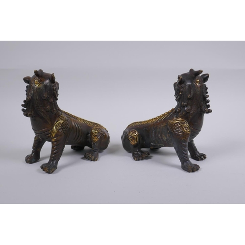 150 - A pair of Chinese filled bronze kylin with gilt highlights, impressed seal mark to base, 14cm long, ... 