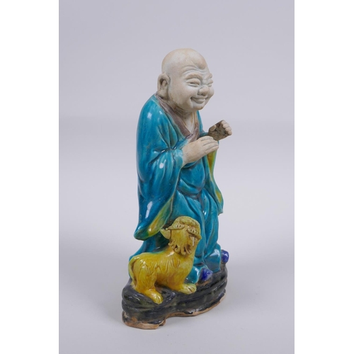 158 - A Chinese polychrome porcelain figure of Lohan with a fo dg, AF, 21cm high