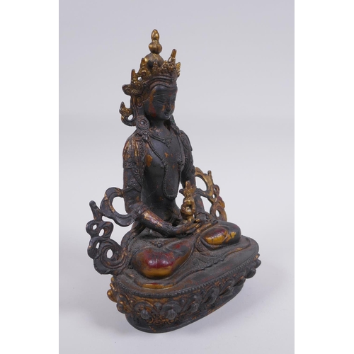 163 - A Sino Tibetan bronze figure of Buddha, with remnants of gilt and copper patina, 22cm high