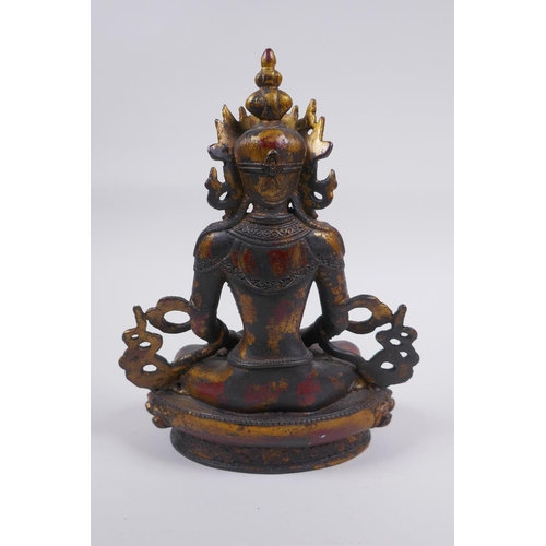 163 - A Sino Tibetan bronze figure of Buddha, with remnants of gilt and copper patina, 22cm high