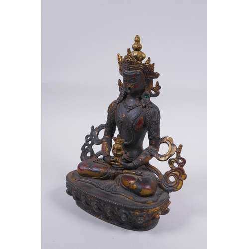 163 - A Sino Tibetan bronze figure of Buddha, with remnants of gilt and copper patina, 22cm high