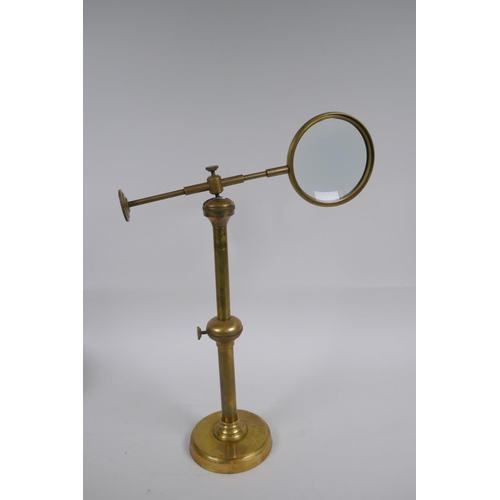 172 - An adjustable brass table top magnifying glass, 24 cm high collapsed