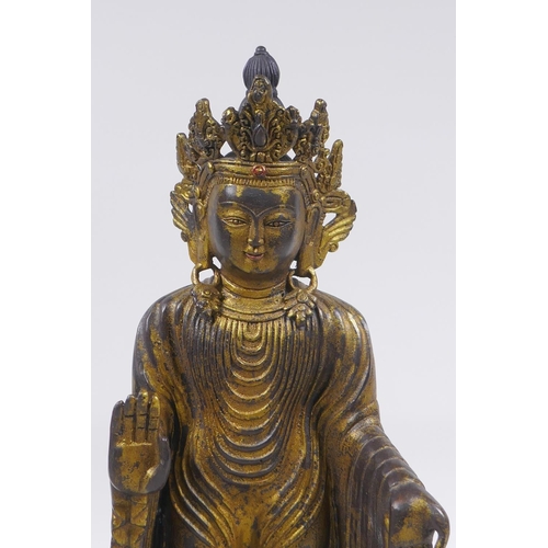 178 - A Sino Tibetan gilt bronze figure of Buddha standing on a lotus flower, 32cm high