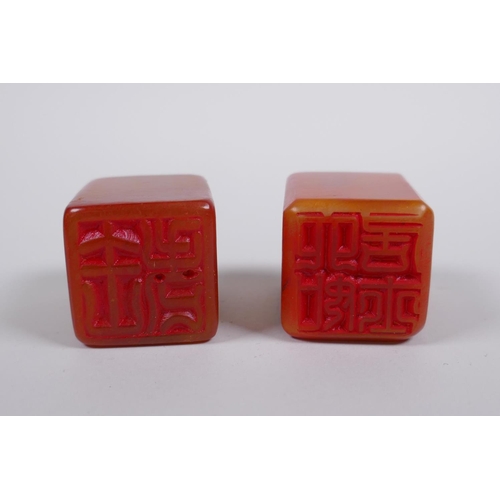 183 - A pair of Chinese amber soapstone seals with dragon mask and lotus pad decoration, 3 x 3cm, 4cm high