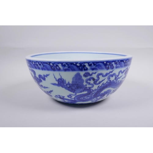 200 - A blue and white porcelain bowl decorated with dragons in flight, Chinese Xuande 6 character mark to... 