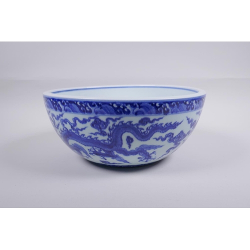 200 - A blue and white porcelain bowl decorated with dragons in flight, Chinese Xuande 6 character mark to... 