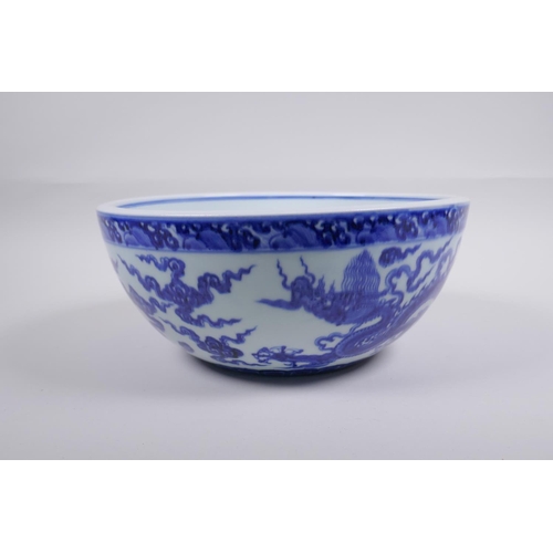 200 - A blue and white porcelain bowl decorated with dragons in flight, Chinese Xuande 6 character mark to... 