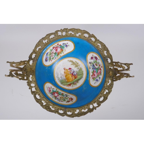 202 - An ormolu mounted Sevres style porcelain centrepiece with decorative panels depicting a courting cou... 