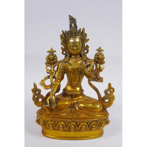 210 - A Tibetan gilt bronze figure of a female deity seated on a lotus flower, impressed double vajra mark... 