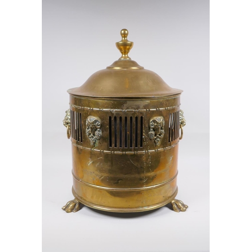 217 - An antique brass coal scuttle with two lion mask loop handles, rams mask decoration and pawed feet, ... 