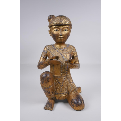 221 - A Tibetan carved gilt and painted wood figure of a musician with inset glass decoration, 38cm high, ... 