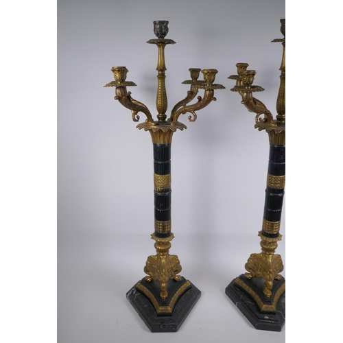 26 - A pair of Empire style bronze and ormolu Corinthian column four branch candelabra, 80cm high