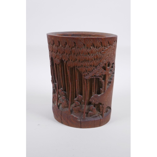 28 - A late C19th/early C20th Chinese carved bamboo brush pot decorated with scholars in a bamboo forest,... 