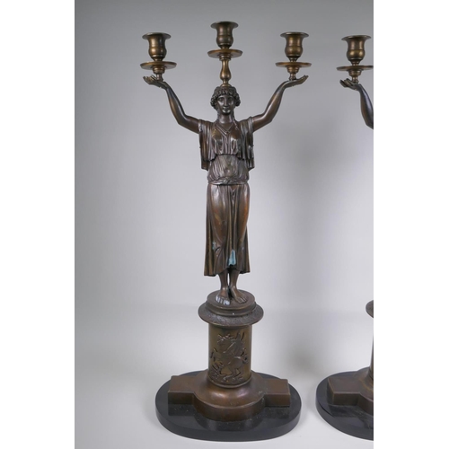 39 - A pair of Empire style bronze three branch figural candlesticks in the form of classical women, 74cm... 