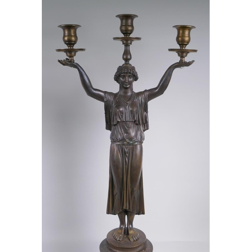 39 - A pair of Empire style bronze three branch figural candlesticks in the form of classical women, 74cm... 