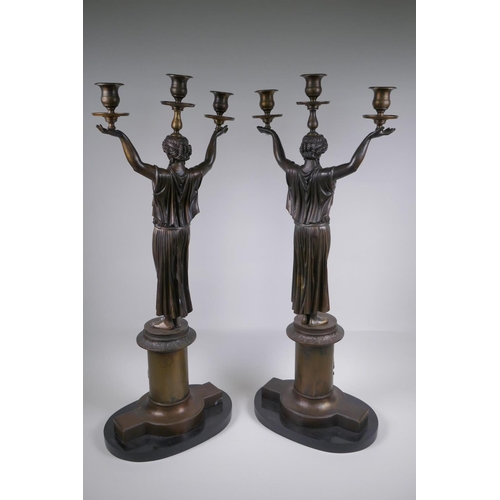 39 - A pair of Empire style bronze three branch figural candlesticks in the form of classical women, 74cm... 