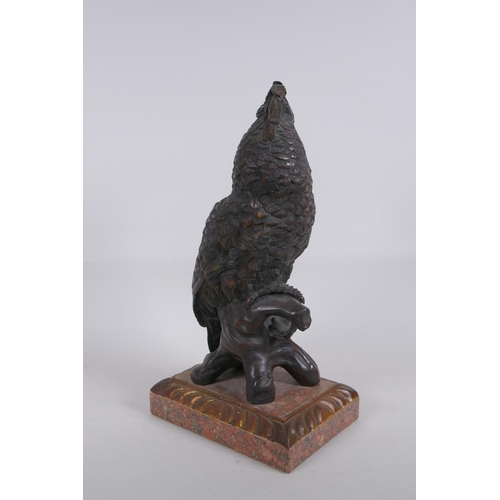 5 - A bronze figure of a cockatoo after Bergman, raised on a parcelgilt wood and marble base, 36cm high