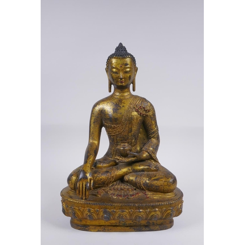 52 - A Sino Tibetan filled gilt bronze figure of Buddha, impressed double vajra mark to base, 30cm high