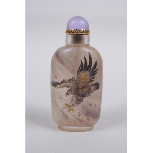 60 - A Chinese reverse decorated glass snuff bottle depicting eagles in flight, 9cm high