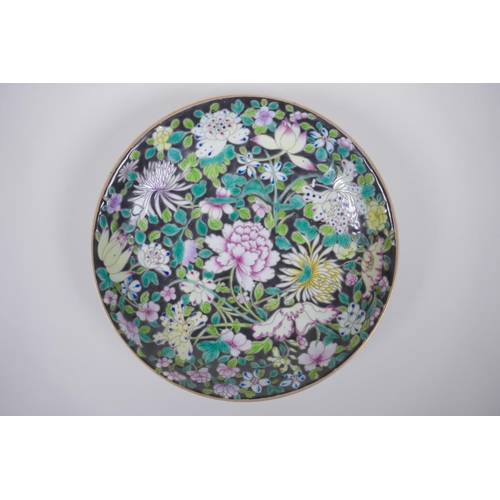 66 - A Chinese famille noir porcelain dish decorated with asiatic flowers, YongZheng 6 character mark to ... 