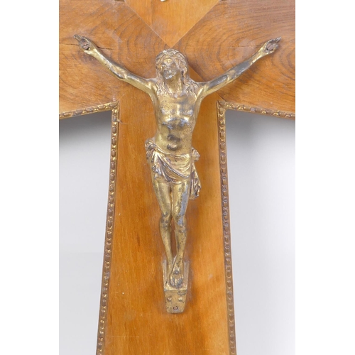 71 - A gilt bronze and wood crucifix with applied repousse brass mounts, and another wooden crucifix with... 