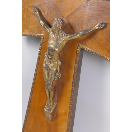 71 - A gilt bronze and wood crucifix with applied repousse brass mounts, and another wooden crucifix with... 