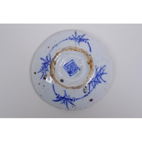 73 - A Chinese Ming style blue and white porcelain tea bowl and red and white porcelain saucer with shape... 