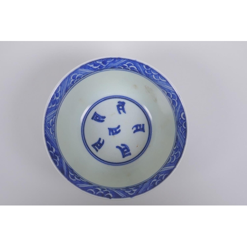 75 - A Chinese blue and white porcelain rice bowl with script and lotus flower decoration, 13cm diameter