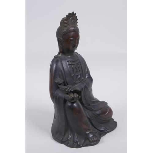 80 - A Chinese bronze figure of Quan Yin seated and holding a ruyi, 23cm high