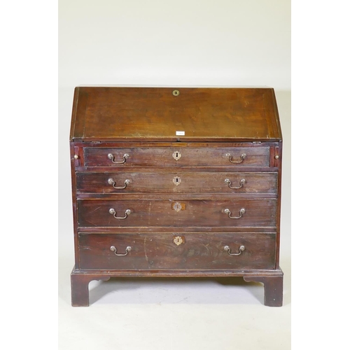 1108 - A Georgian mahogany bureau with four graduated drawers, the fall front fitted with pigeon holes and ... 