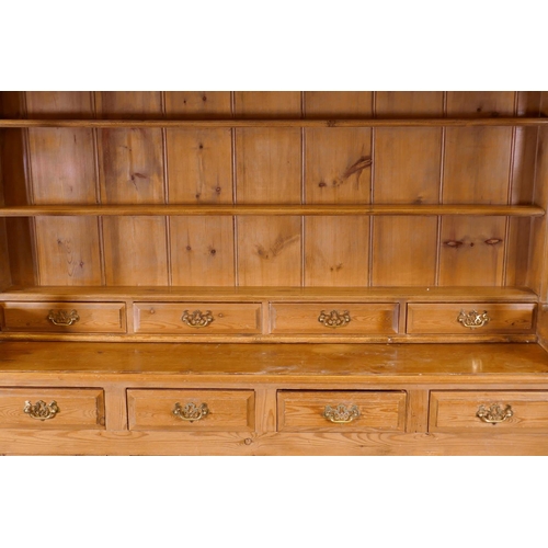 1120 - A pine dresser, the upper section with delft rack over four drawers, open sides, the base with four ... 