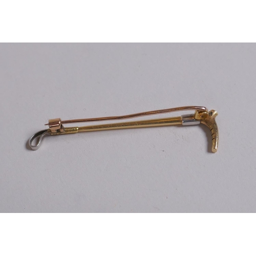 655 - A 15ct gold and white metal riding crop brooch, 3g gross, 5cm